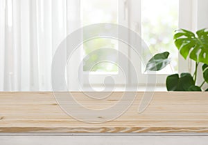 Wooden table top for product display over blurred curtained window
