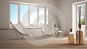 Wooden table top or shelf with aromatic sticks bottles over blurred modern living room with carpet and armchairs, white architectu photo
