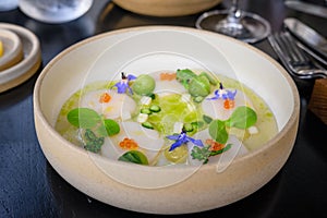 Wooden table with a white plate with a fine dining scallops