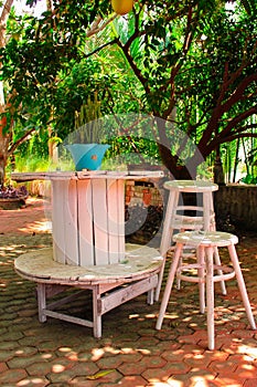 Wooden tables and chairs under a tree.