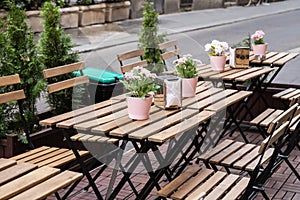 Wooden tables are on the street. A cozy cafe. A place to relax.