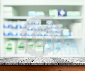 Wooden tabletop with blurred pharmacy or medicine shelf