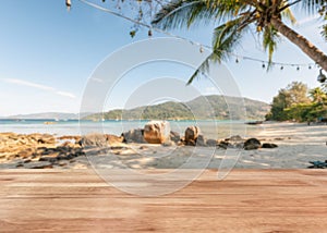 Wooden tabletop on coconut tree with rocks on the beach