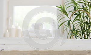 Wooden tabletop with copy space over blurred spa window background