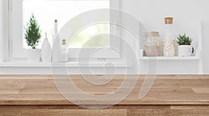 Wooden tabletop in front of blurred kitchen window, shelves background