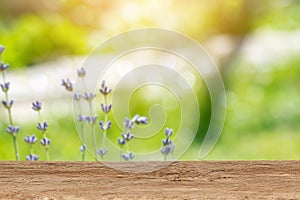 Wooden tabletop for product placement with a blury floral background. Place for displaying product mockups