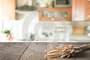 Wooden tabletop with wheat on blur kitchen room background for montage product.