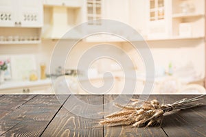 Wooden tabletop with wheat on blur kitchen room background for montage product.