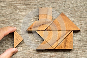 Wooden tangram puzzle in home shape wait for completion Concept