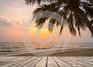 Wooden terrace over tropical island beach with coconut palm at sunset or sunrise time