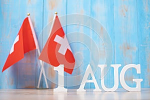 Wooden text of August 1st with miniature Switzerland flags. Switzerland National Day and happy celebration concepts