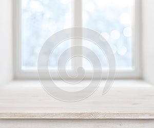 Wooden texture table surface over abstract frosty winter window background