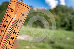 Wooden thermometer during hot summer showing high temperature.