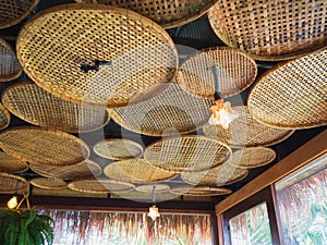 Wooden threshing baskets on ceiling and light lamp.