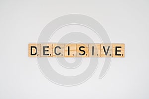 Wooden tile spelling the word decisive isolated on a white background