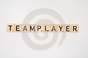 Wooden tile spelling the word teamplayer isolated on a white background