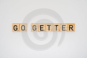 Wooden tile spelling the words go getter on a white background photo