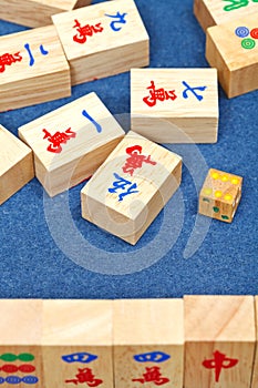 Wooden tiles in mahjong game on blue cloth table