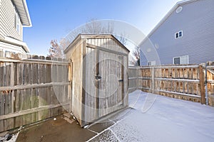 Wooden tool shed at the backyard with wooden fence