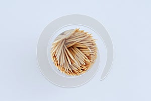 Wooden toothpicks in round package on white background close-up