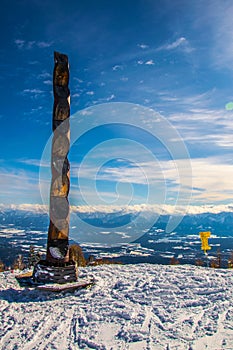 a wooden totem situated on the gerlitzen mountain near villach with dolomites alps on background...IMAGE