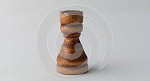 Wooden tower chess figure on grey background