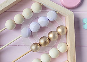 Wooden toy abacus, numbers, blocks, pastel color on pink background. Natural no plastic toys for creativity development.