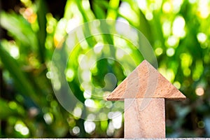 Wooden toy as dream house concept with blurred green background