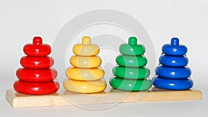 Wooden toy for baby, children isolated on white background. Rings of different colors and sizes placed on stakes of the same color