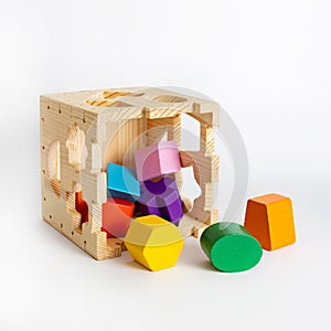 Wooden toy blocks cube shape sorter, colorful details isolated on white background, early development of logic for