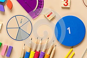 Wooden toy blocks. School supplies, math fractions, pencils, numbers, on beige background. Back to school, education concept