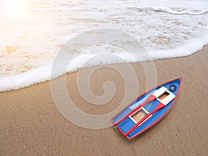 Wooden toy boat on the beach