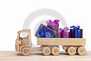 Wooden toy car with gifts. Boxes in holiday packaging.