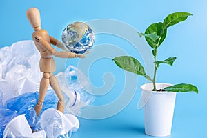 Wooden toy carry the planet to green plant to save the earth from garbage. Waste recycling. Elements furnished by NASA