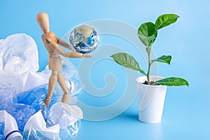 Wooden toy carry the planet to green plant to save the earth from garbage. Waste recycling. Elements furnished by NASA