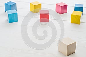 Wooden toy cubes on a white wooden background.