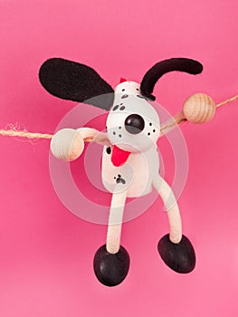 Wooden toy dog on a pink background