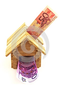 Wooden toy house with euro paper money