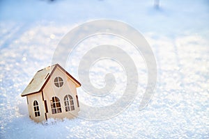 Wooden toy house on snow, natural abstract background. winter season concept. Christmas and new year holidays. symbol of