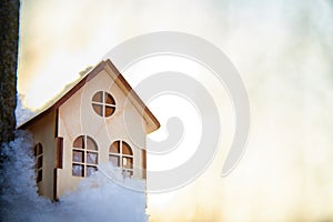 Wooden toy house on snow, natural abstract background. winter season concept. Christmas and new year holidays. symbol of