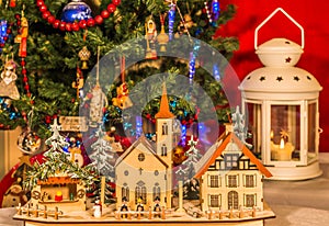 Wooden toy houses on a background of the Christmas tree.