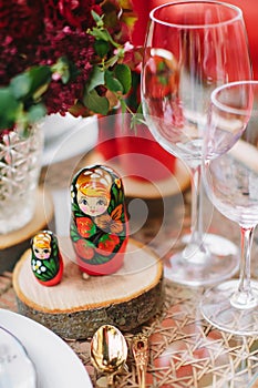 Wooden toy - matryoshka. Table setting in national Russian style. Red in decor and decoration.