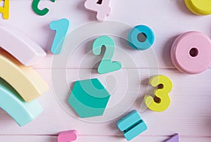 Wooden toy rainbow, numbers, blocks, pastel color arc on pink background. Natural no plastic toys for creativity development.