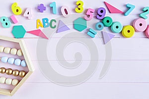 Wooden toy rainbow, numbers, blocks, pastel color arc on pink background. Natural no plastic toys for creativity development.