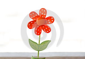 wooden toy red flower with white spots and green leaves isolated on white background.