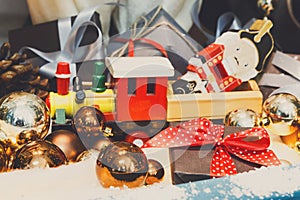 Wooden toy train as christmas gift with shiny baubles, holiday b