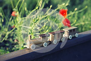 Wooden toy train on real railway tracks