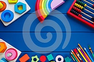 Wooden toys, cubes, brushes on classic blue background. Back to school background. Close up. Top view, copy space. Education