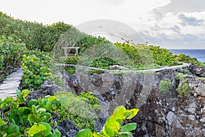 Wooden trail path on mountain cliff side by the ocean. Scenic outdoor mountainside setting in peaceful countryside