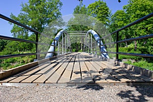 Wooden trail with small bridge through wood forest with heave planks in wood